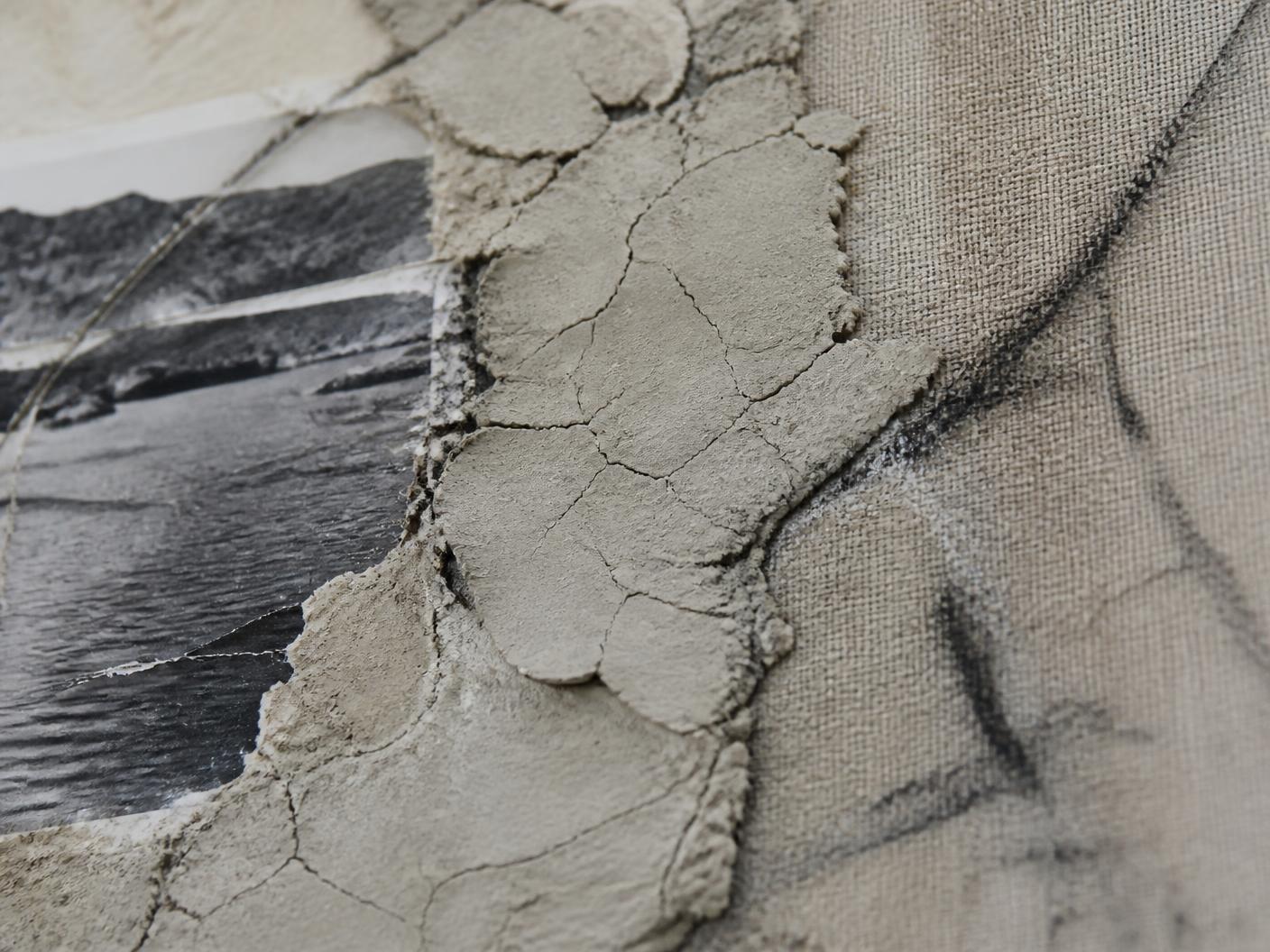 Macro detail of cracked clay, charcoal and a photographic fragment on raw linen
